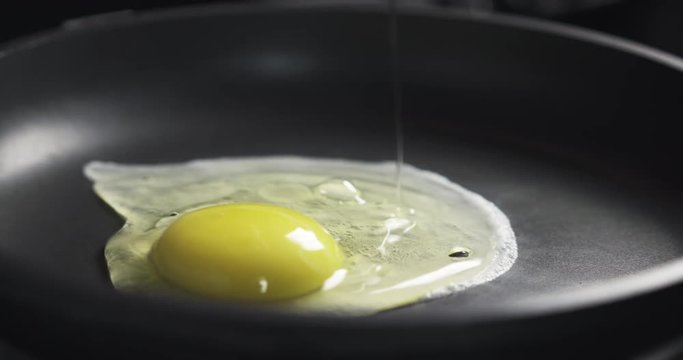egg falling in frying pan in slow motion