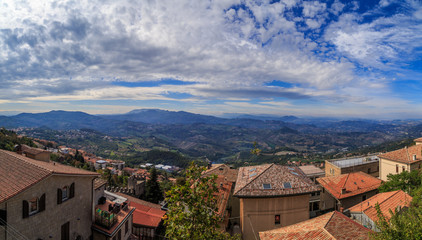 Fototapeta na wymiar The view from the observation platform of Mount Titano, hills, clouds, a tiled roof