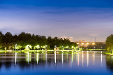 Fototapeta na wymiar Dramatic night park illumination reflections background