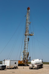 Obraz premium Oil drilling crew, called roughnecks, work a derrick rig in the oil well fields.