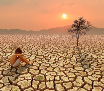 Child sit on cracked earth in the arid area
