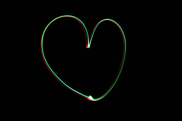 Light painting heart shape over black background