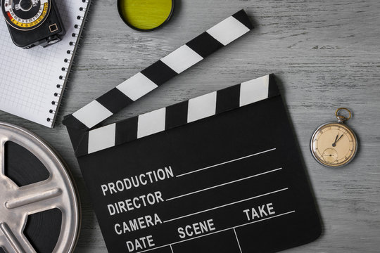 Clapperboard, a roll of film and watch