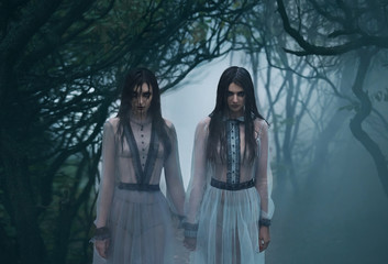 Two mysterious sexy lady's with long black hair, in eerie they woods looking at you