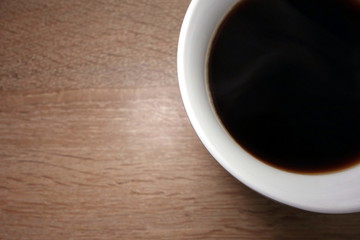 Coffee cup on wooden background, closeup view from overhead