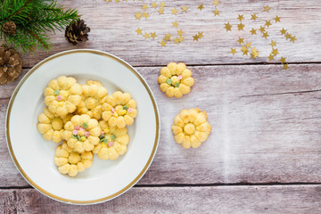 Homemade vanilla cookies with winter decoration on white plate, top view.
