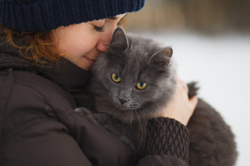 Pretty girl holds a gray cat - 127418945