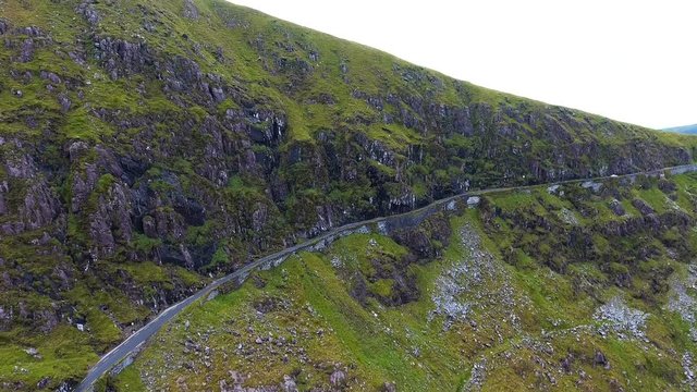 The view of the Skyroad on the side of the mountain with the big rocks on the side and the blue sky in Ireland