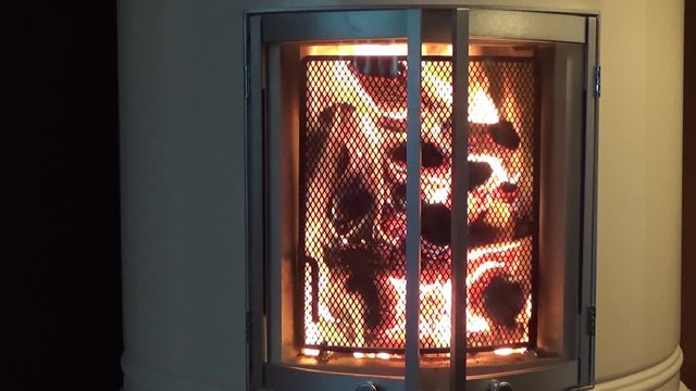 Firewood burning in a livingroom fireplace - parallel closeup