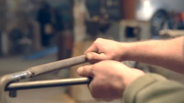 Close-up blacksmith shapes the metal manually