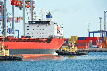 Tugboat assisting bulk cargo ship