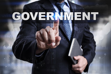 Businessman is pressing button on touch screen interface and selecting government.