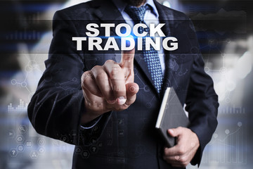 Businessman is pressing button on touch screen interface and selecting stock trading.