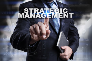 Businessman is pressing button on touch screen interface and selecting strategic management.