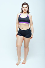 Portrait of a young woman in sports underwear on a white background