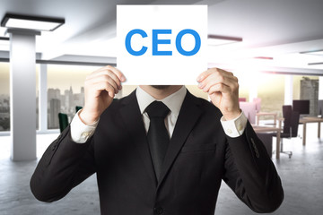 businessman hiding face behind sign ceo