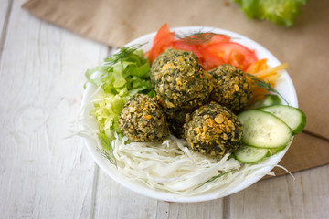Falafel salad on white bowl.