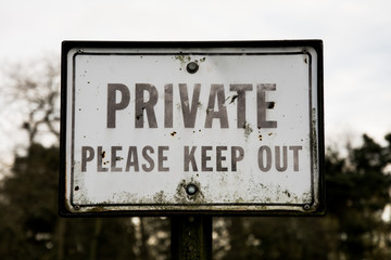 Metal sign saying, 'Private - Please Keep Out'. Relates to the idea of online privacy and trespassing. 