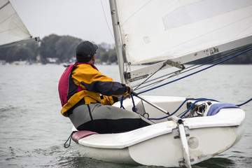 Fototapeta premium Man in the Finn-Class sailboat participates in one of the match race regattas on the Sava river, Belgrade, Serbia