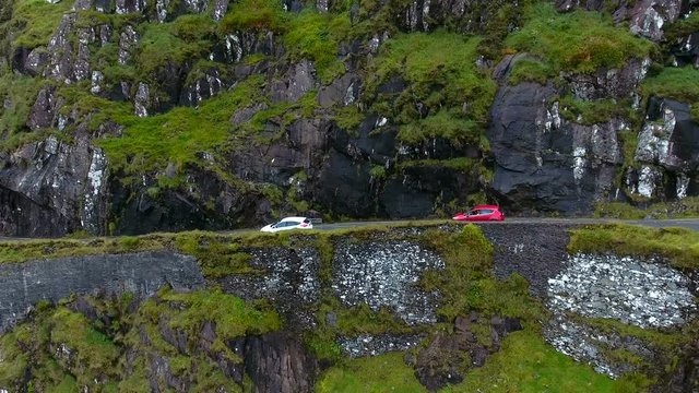 Cars passing by the Skyroad the road found on the side of the big mountain as one of the tourist destinations in Ireland