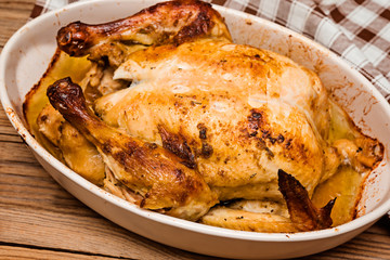 Roasted chicken on wooden rustic background. Selective focus