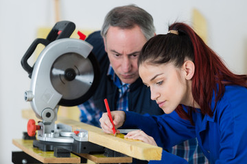 carpentry teacher showing sawing machine to students