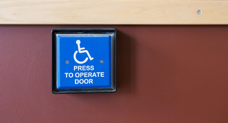 Handicapped access entrance pad on a wall.