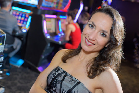woman in casino next to a slot machine