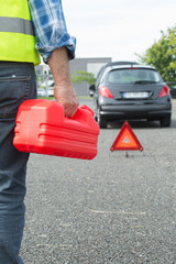 senior aged man holding gas can to refill his car