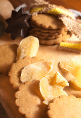 candied ginger and round cookies over wooden cutting board