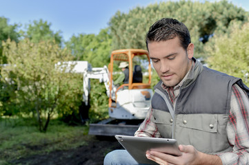Gardener outdoors, using tablet