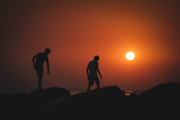 two guys at sunset at sea