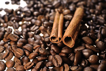 Coffee beans with cinnamon sticks on white
