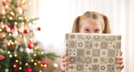 child holding christmas present - Powered by Adobe