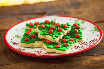 Christmas Tree Cookies Close Up On Holiday Plate By Warm Glowing Fire.