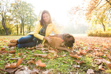 Beautiful young woman playing with her Dog in the forest	