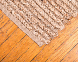 Jute pile hand woven beige area rug on old hardwood floor