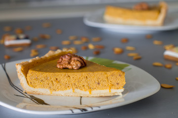 Two slices traditional pumpkin pie decoration halves of walnut