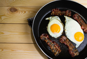 Scrambled eggs with bacon in a frying pan
