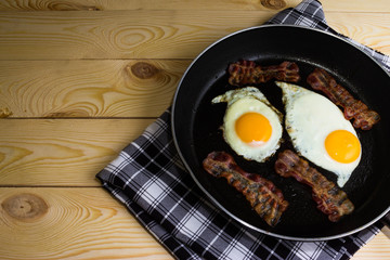 Scrambled eggs with bacon in a frying pan