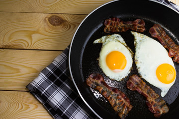 Scrambled eggs with bacon in a frying pan
