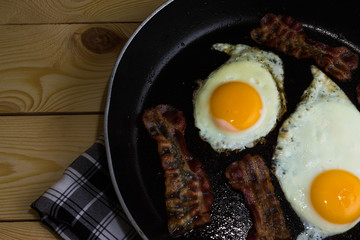 Scrambled eggs with bacon in a frying pan