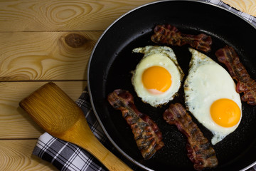 Scrambled eggs with bacon in a frying pan