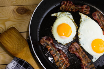 Scrambled eggs with bacon in a frying pan