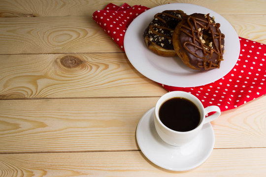 Cup of coffee with chocolate donuts