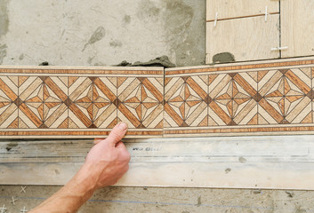 Worker putting tiles on the floor.
