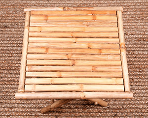 Natural bamboo folding table on jute pile hand woven area rug