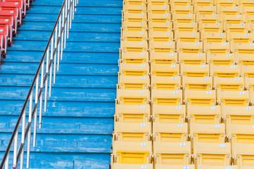 Empty orange and yellow seats at stadium,Rows of seat on a soccer stadium