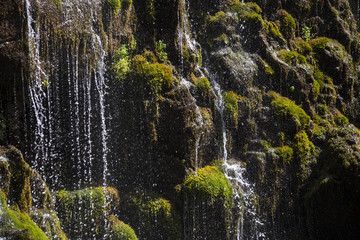 Waterfall cascading over rocks .