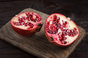 pomegranate cut with a knife on a wooden board. view from above
